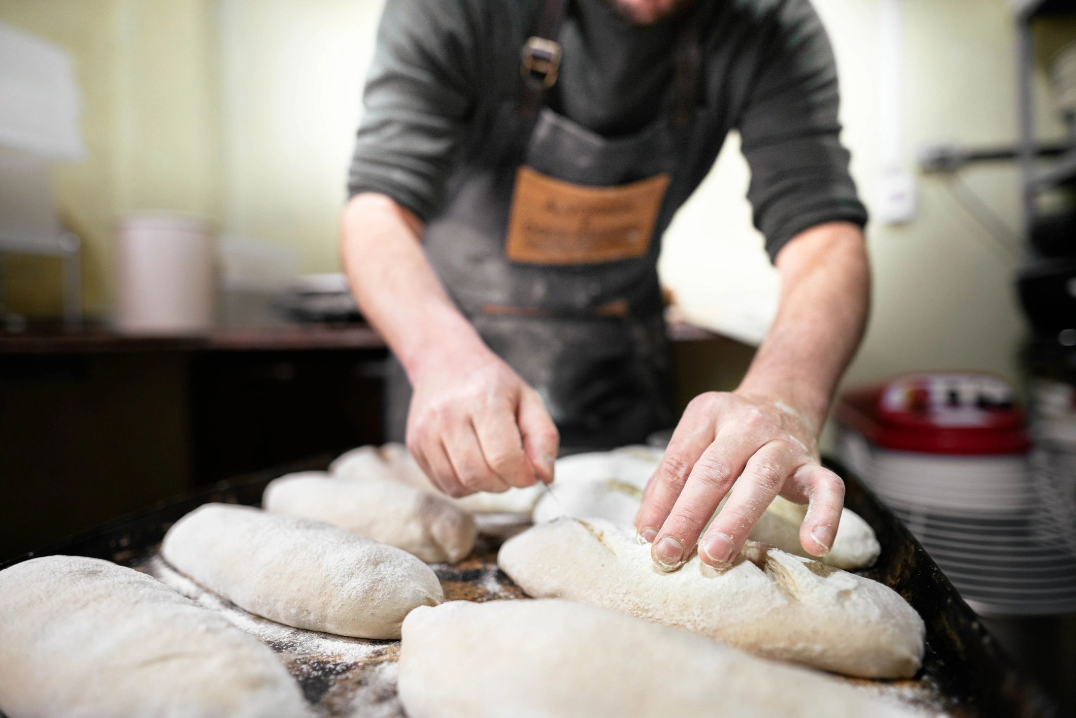 Baker preparing loaves before baking