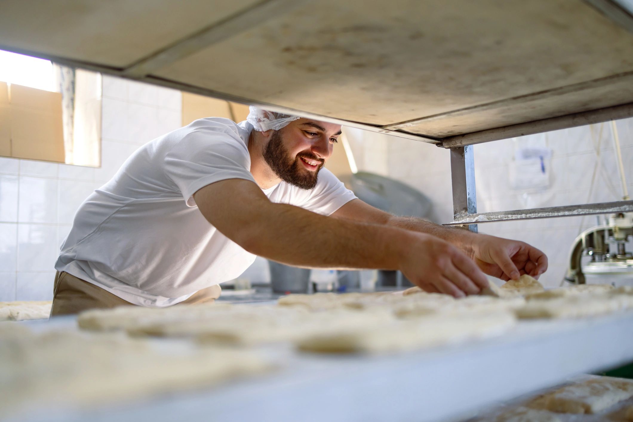 Baker preparing dough on a work surface