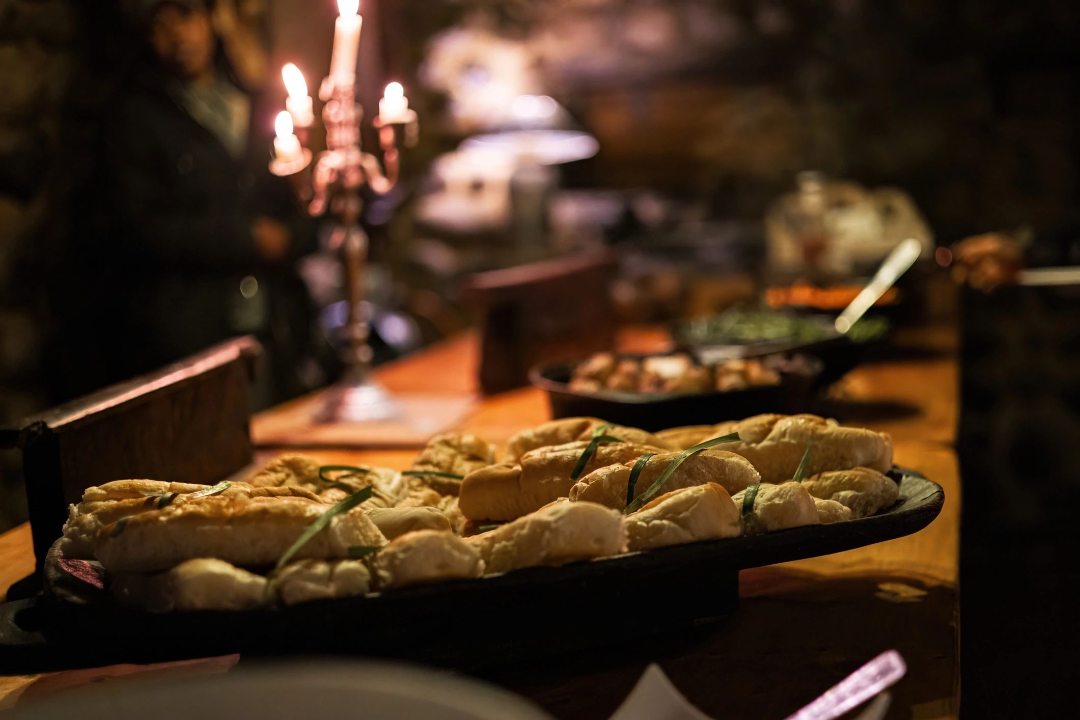 Bread on a warmly lit table with candles